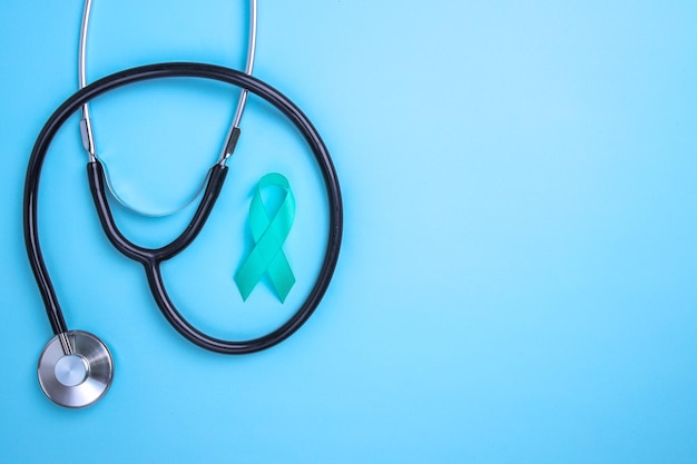 Photo teal awareness ribbon and stethoscope to support cancer survivor