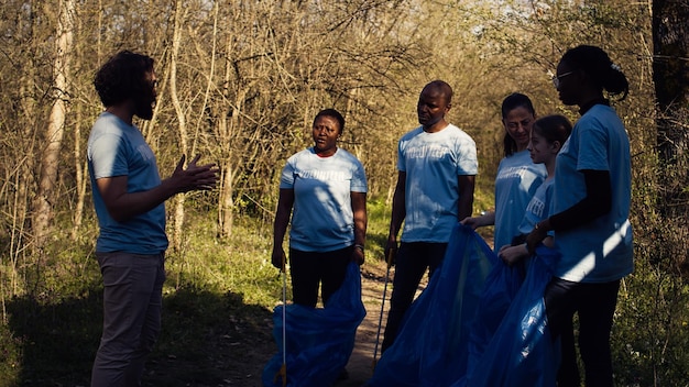 Foto una squadra di attivisti che raccoglie i rifiuti di plastica per riciclare e raccogliere la spazzatura