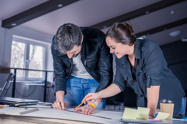 Team of architects people drawing construction project with pencil and ruler on desk