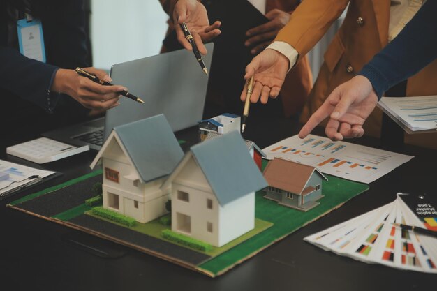 建築家とビジネスマンのチームが不動産投資と住宅開発プロジェクトのフロアプラン変更について議論しブレインストーミングを行っています