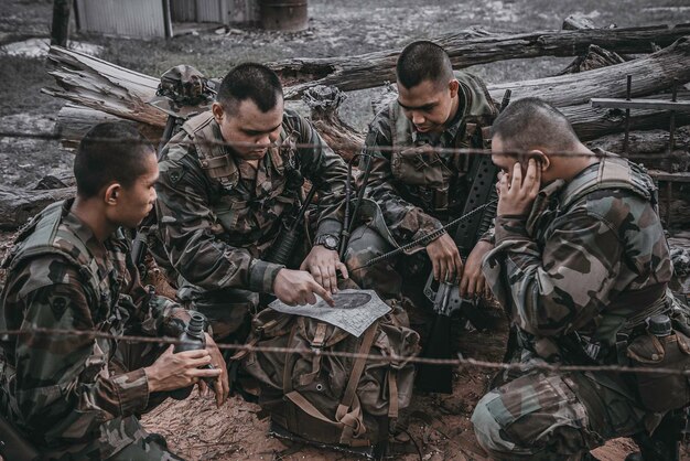 Team of army soldier with machine gun moving in the forestthai\
militia soldier in combat uniforms in the woodwander the patrol\
sloping in the rainforest