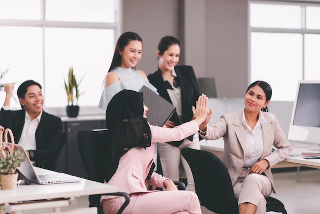 Team asian people giving hands high five together at office,Teamwork successful meeting finishing up