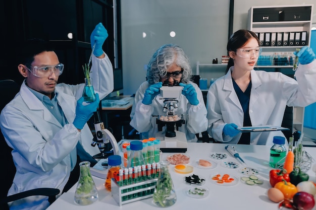 アジアの科学者チームが微鏡と実験室機器を使用して食品研究を行い食品科学とバイオテクノロジーのイノベーションを展示しています