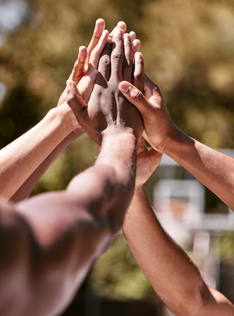 Team basketball and hands doing high five after success winning and goal in sports game Diversity teamwork and celebration in training practice and match motivation to win on basketball court