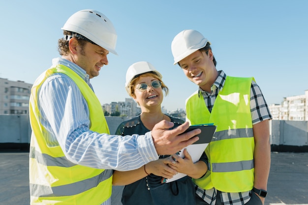 Team of builders engineer architect on the roof of construction site