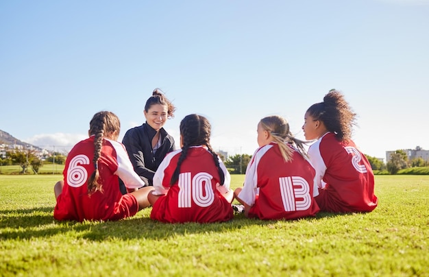 Foto pianificazione del team building o allenatore con i bambini per l'allenamento di strategia calcistica e obiettivi sportivi in canada amici dello sport e donne che allenano un gruppo di ragazze sul campo di calcio per una partita o un allenamento