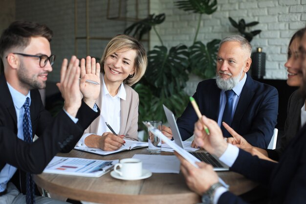 Foto team di uomini d'affari che discutono a tavola in ufficio creativo.