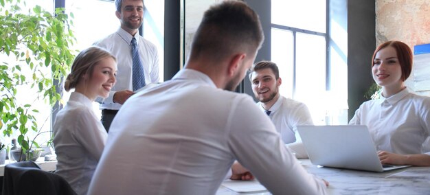 Team of business people having discussion at table in creative office