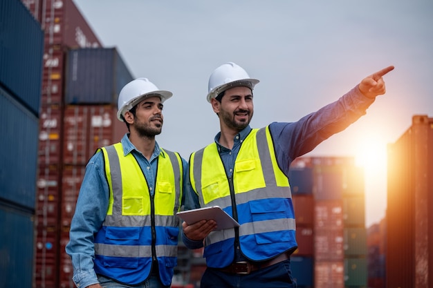 Team businessman working on site containers yard for business
shipping import and export caucasian worker inspecting container in
warehouse logistic delivery services export management team