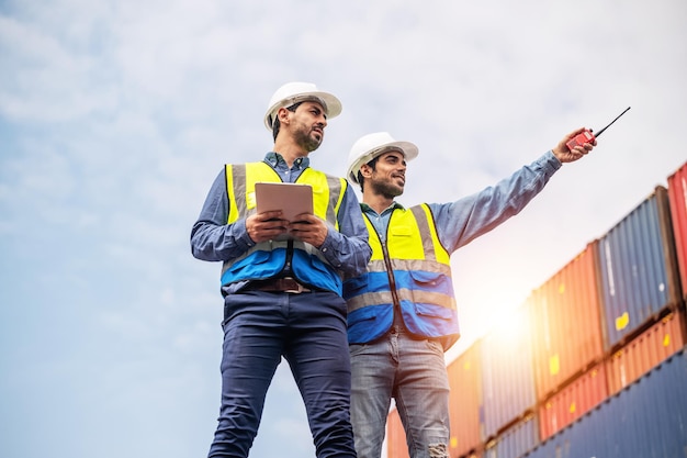 Uomo d'affari del team che lavora sul cantiere di container in loco per l'importazione e l'esportazione di spedizioni aziendali lavoratore caucasico che ispeziona il container nel team di gestione delle esportazioni dei servizi di consegna logistica del magazzino