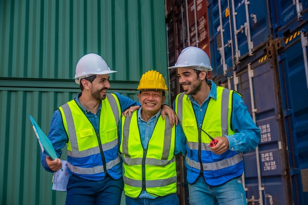 Team businessman working on site containers yard for business\
shipping import and export caucasian worker inspecting container in\
warehouse logistic delivery services export management team