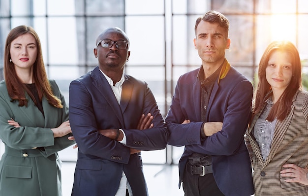 Foto una squadra di uomini d'affari si trova in un ufficio alla moda con le braccia incrociate