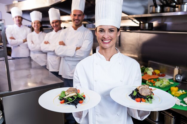 Photo team of chefs with one presenting dishes