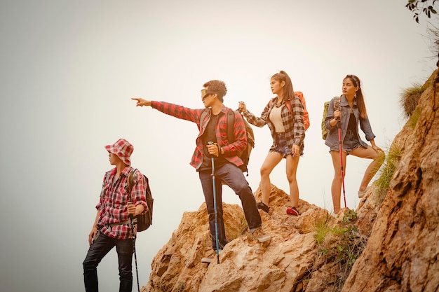 Team of climbers man and woman hiker holding hands to help each other up the hill with red flags for hiking for mountain climbing success. Hiking, hikers, team, mountain, climb, activity concept.