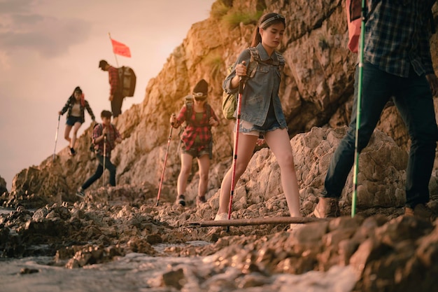 Team of climbers man and woman hiker holding hands to help each other up the hill with red flags for hiking for mountain climbing success. Hiking, hikers, team, mountain, climb, activity concept.