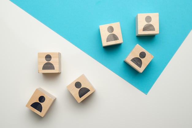 Team competition concept at work with icons on wooden blocks.