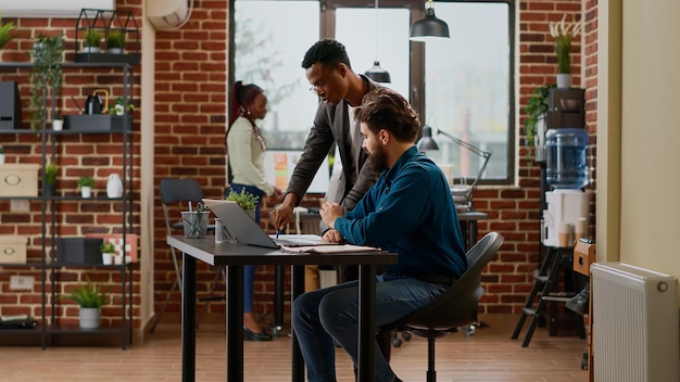 Team of coworkers analyzing data charts and graphs on papers,\
doing teamwork to create project report. people working on\
partnership presentation with business research in office.