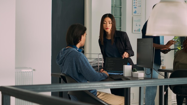 Team of database admins analyzing source code on computer\
monitor, comparing data script in busy agency office. two cloud\
programers debugging algorithm in software developing office.