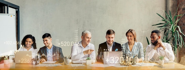 A team of diverse professionals in a meeting with a man leading the discussion at a table