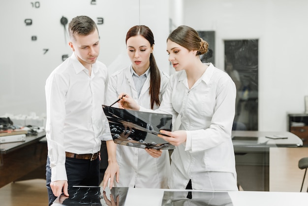 Team of doctors examining x-ray of a patient