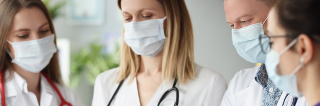 team of doctors in medical protective mask examining the results of medical examination