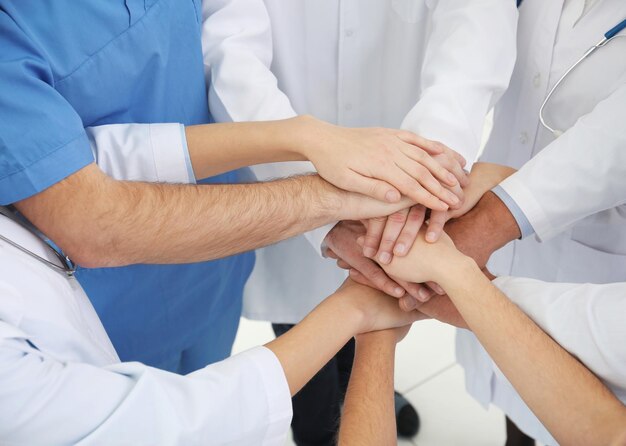 Foto squadra di medici che mettono le mani insieme in primo piano