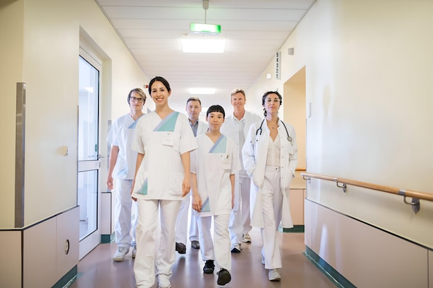 Photo team of doctors walking in hospital corridor