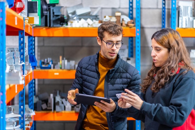 Foto un team di ingegneri che usa un tablet nel magazzino di una fabbrica di cnc