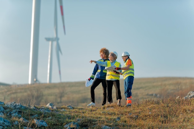 A team of engineers and workers oversees a wind turbine project at a modern wind farm working