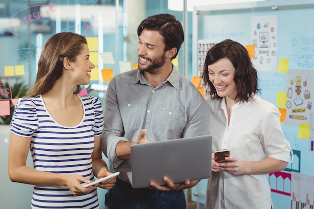 Team of executives discussing over laptop