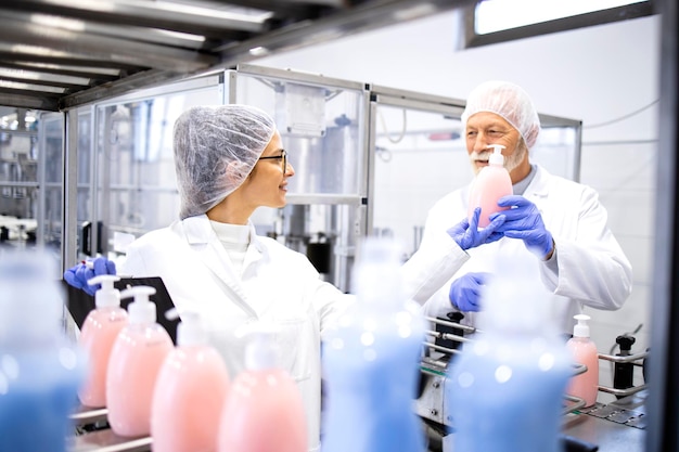 Foto squadra di operai che producono prodotti chimici per la pulizia come shampoo, sapone liquido e detersivo