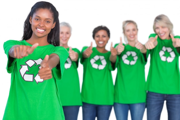 Team of female environmental activists smiling at camera and giving thumbs up