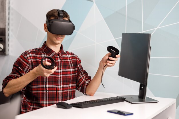 가상 현실 작업을하는 4 명의 창의적인 엔지니어 팀, 사무실 방에 앉아 VR 안경 또는 고글을 테스트하는 젊은 여성