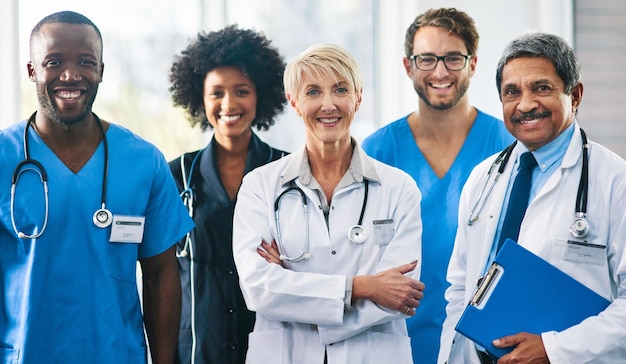 team or group of a doctor nurse and medical professional colleagues or coworkers standing in a hospital together portrait of diverse healthcare workers looking confident and happy about medicine