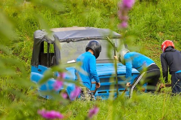 Team in helmet on a blue car gets out of an extreme trap