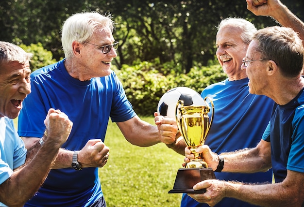 Foto squadra di giocatori di calcio maturi che vincono la coppa