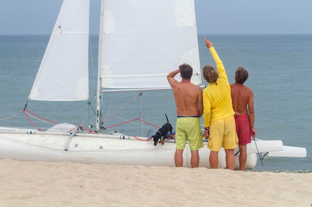 A team of men with a captain standing near the white sail yacht\
black sea zatoka odesa ukraine