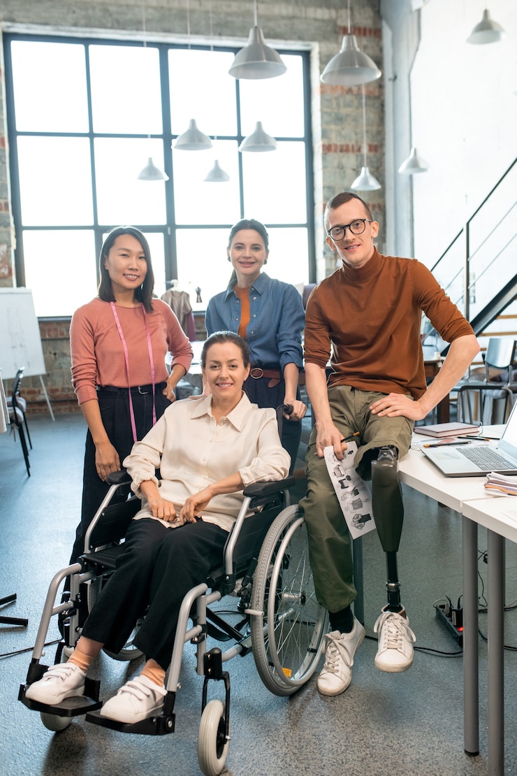 Photo team of modern fashion designers standing in front of camera in studio