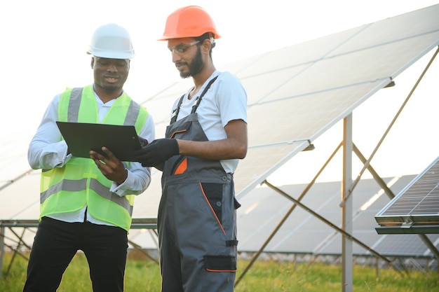 A team of multiracial workers in a field of solar panels