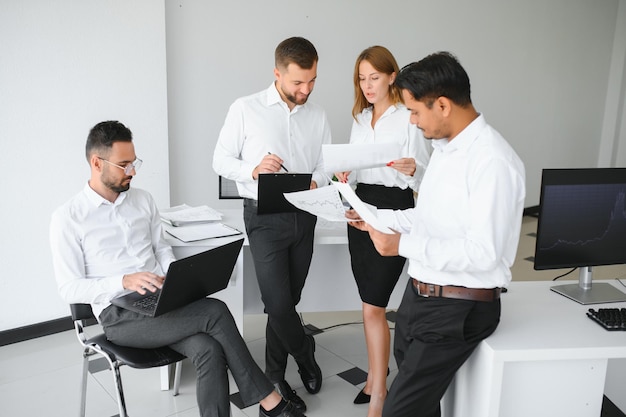 Team op het werk Groep jonge zakenmensen in slimme vrijetijdskleding die samenwerken in een creatief kantoor