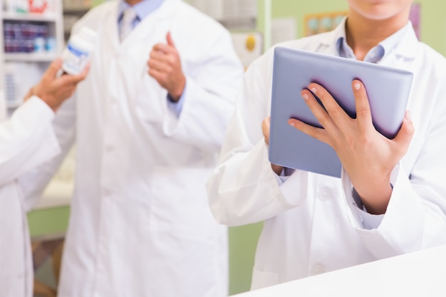 Team of pharmacist using tablet and holding medication