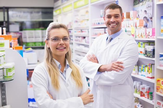 Team of pharmacists smiling at camera at the hospital pharmacy