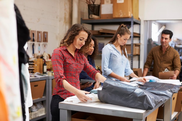 Squadra in una stanza delle poste che prepara gli ordini di vestiti per la distribuzione