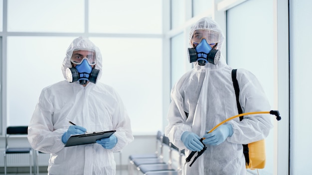 Team of professional male sanitizers works in a public building . photo with a copy-space.