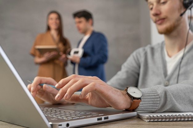 Team di professionisti che utilizzano laptop e cuffie da realtà virtuale