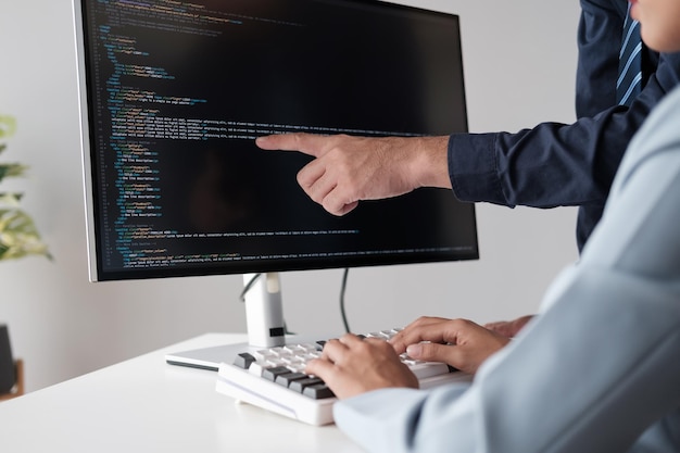 Premium Photo | Team of programmer pointing to desktop computer with ...