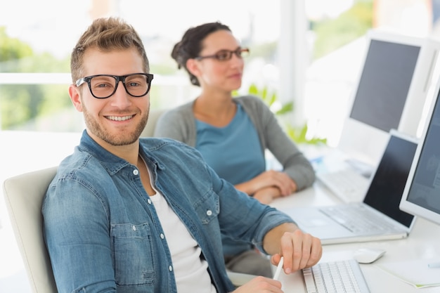 Team of smiling designers with man looking at camera