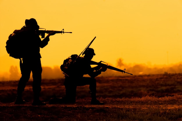 Team special forces.Soldier assault rifle with silencer.Silhouette action soldiers hold weapons.military and danger concept.