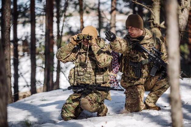 Team of special forces weapons in cold forest winter warfare\
and military concept