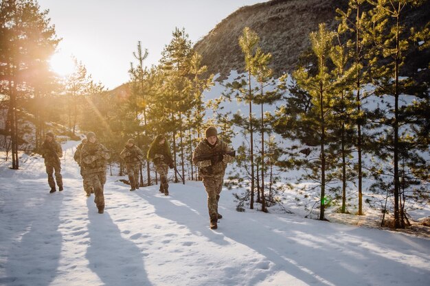 Team of special forces weapons in cold forest winter warfare\
and military concept